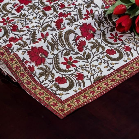 Decorative tablecloth with floral pattern and red flowers on a dark surface