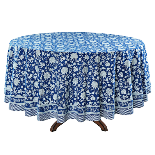 Round table with a blue floral patterned tablecloth on a white background
