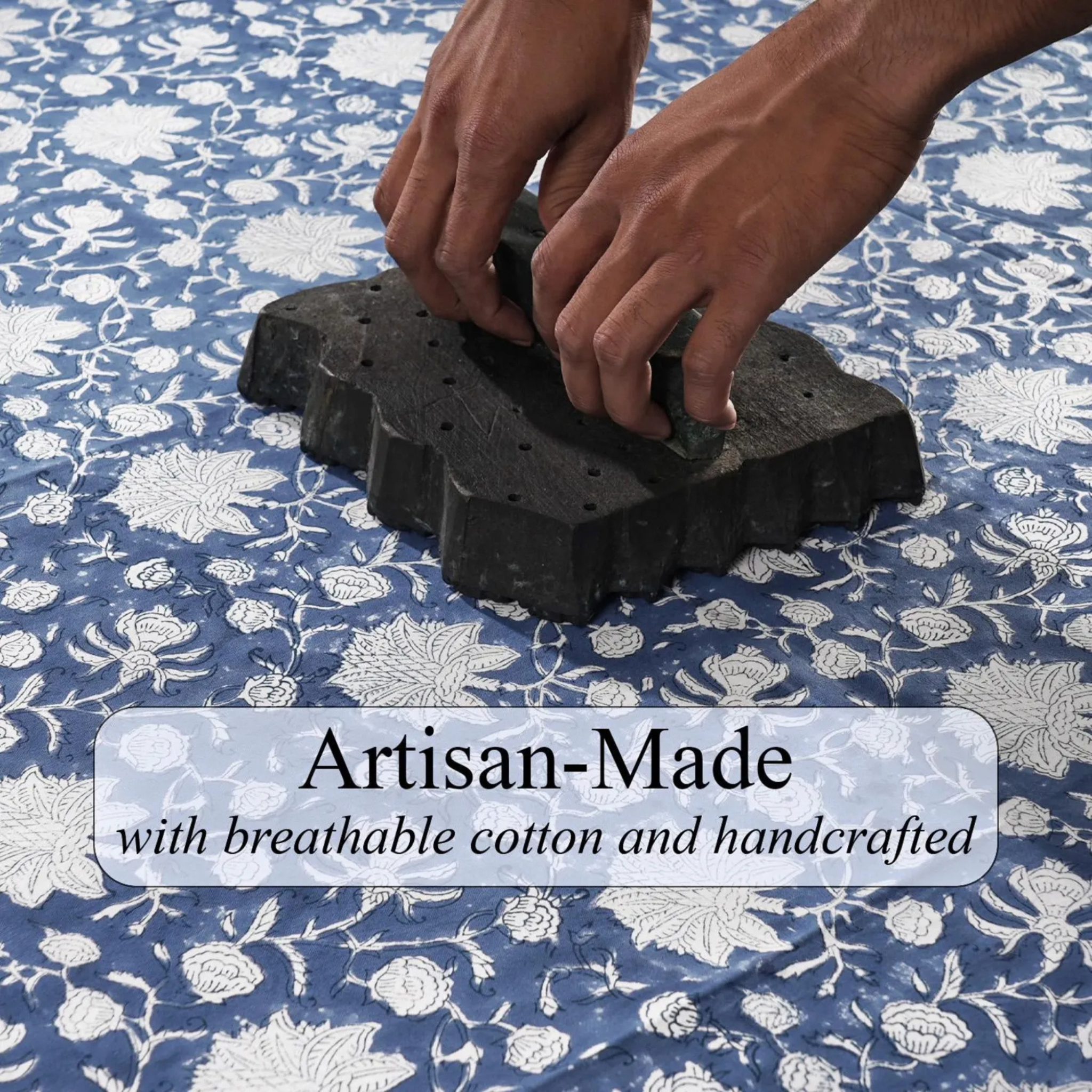 Hands pressing down on a black block with a floral patterned fabric in the background, featuring text 'Artisan-Made with breathable cotton and handcrafted'.