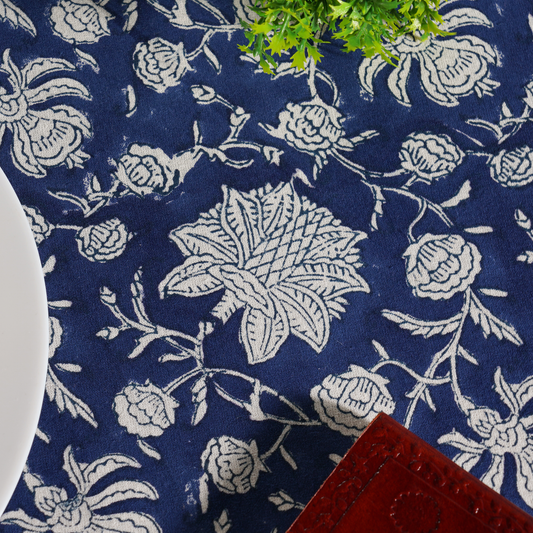 Navy blue fabric with white floral patterns, partially covering a red object.