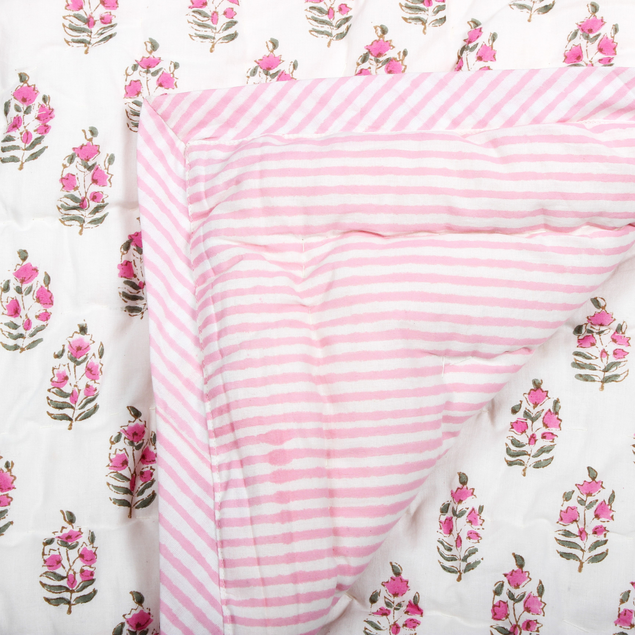 Pink and white striped fabric on a floral patterned background