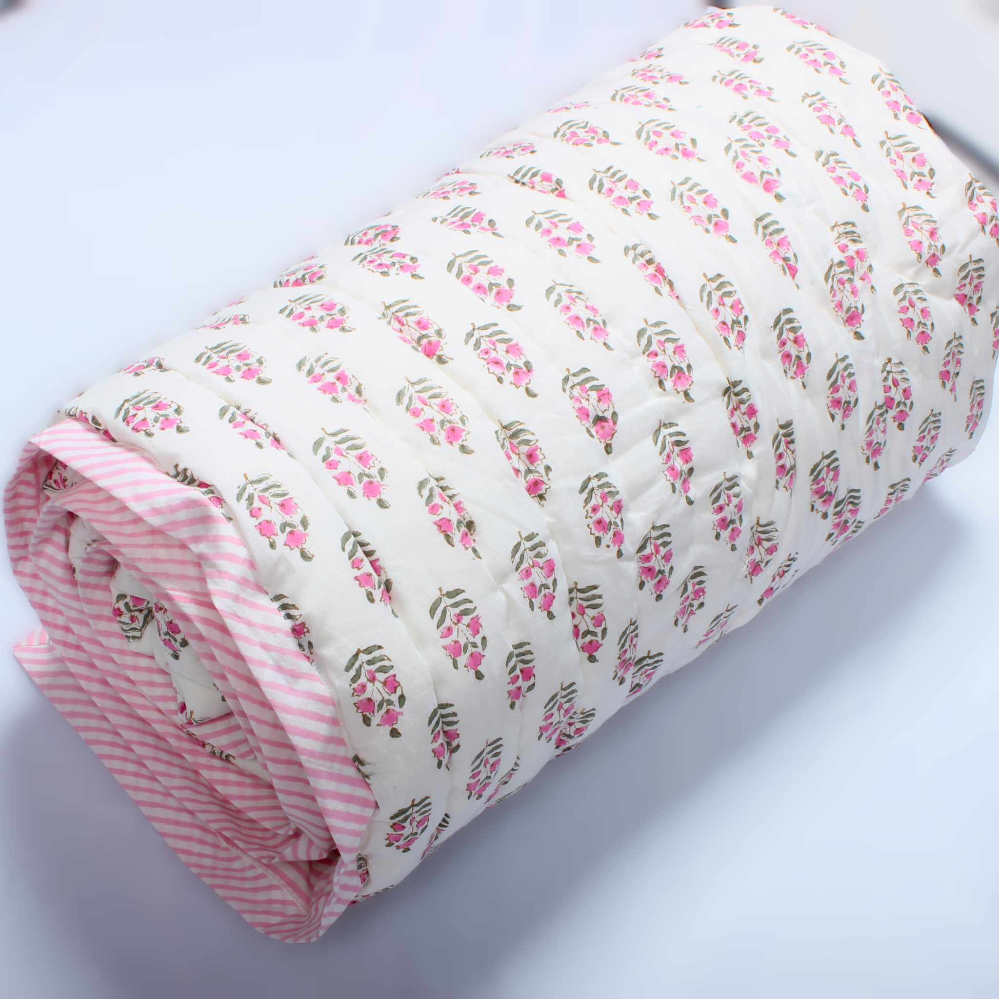 Rolled-up fabric with pink floral pattern on a white background