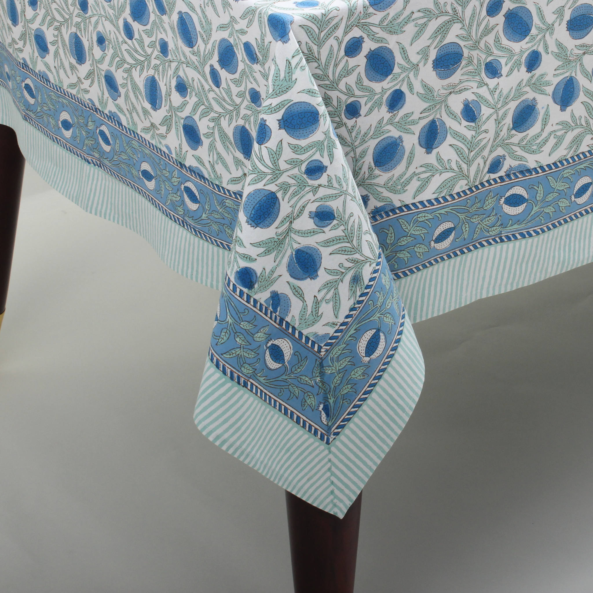 Decorative tablecloth with blue and green pattern on a plain background
