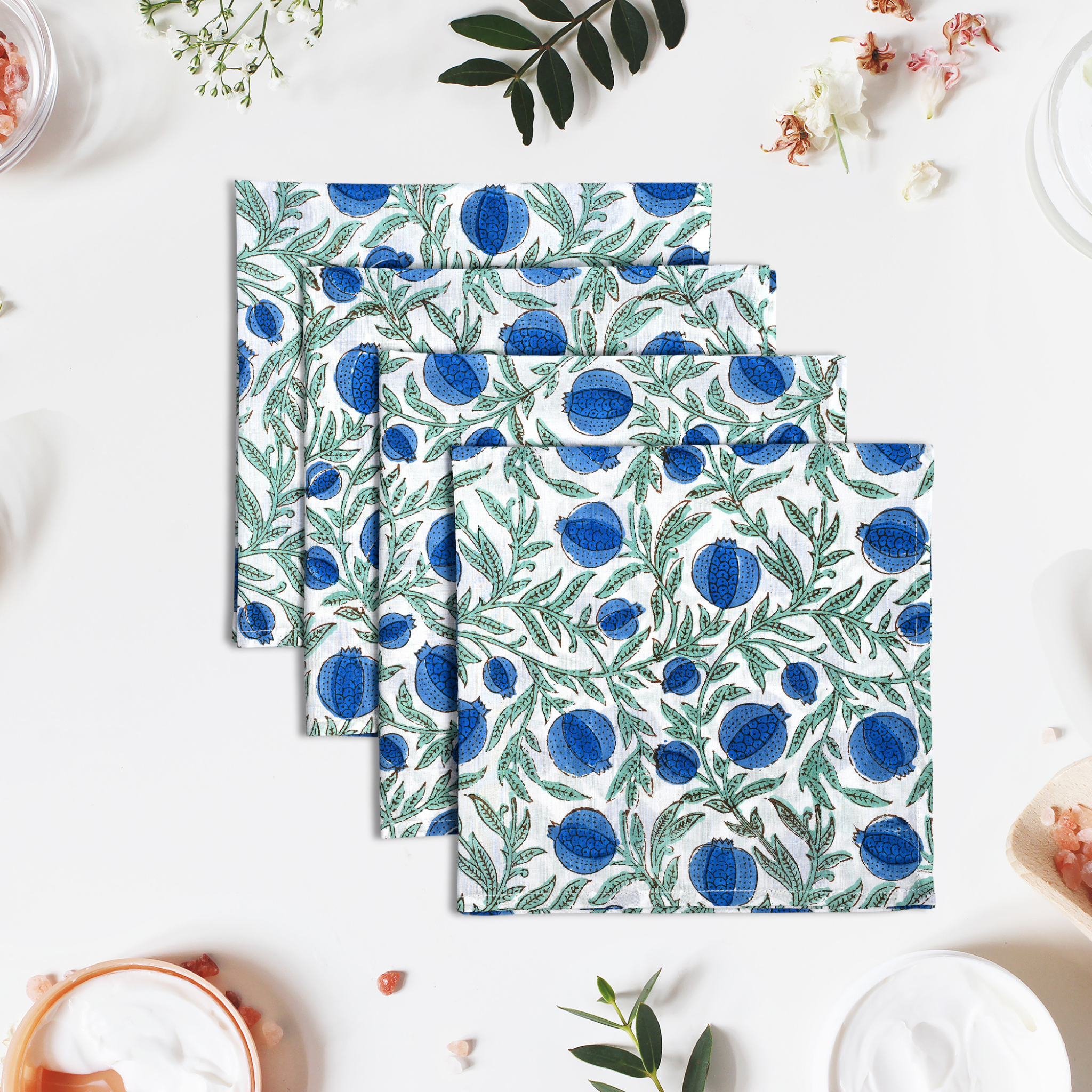 Set of three patterned napkins with blue and green design on a white surface.