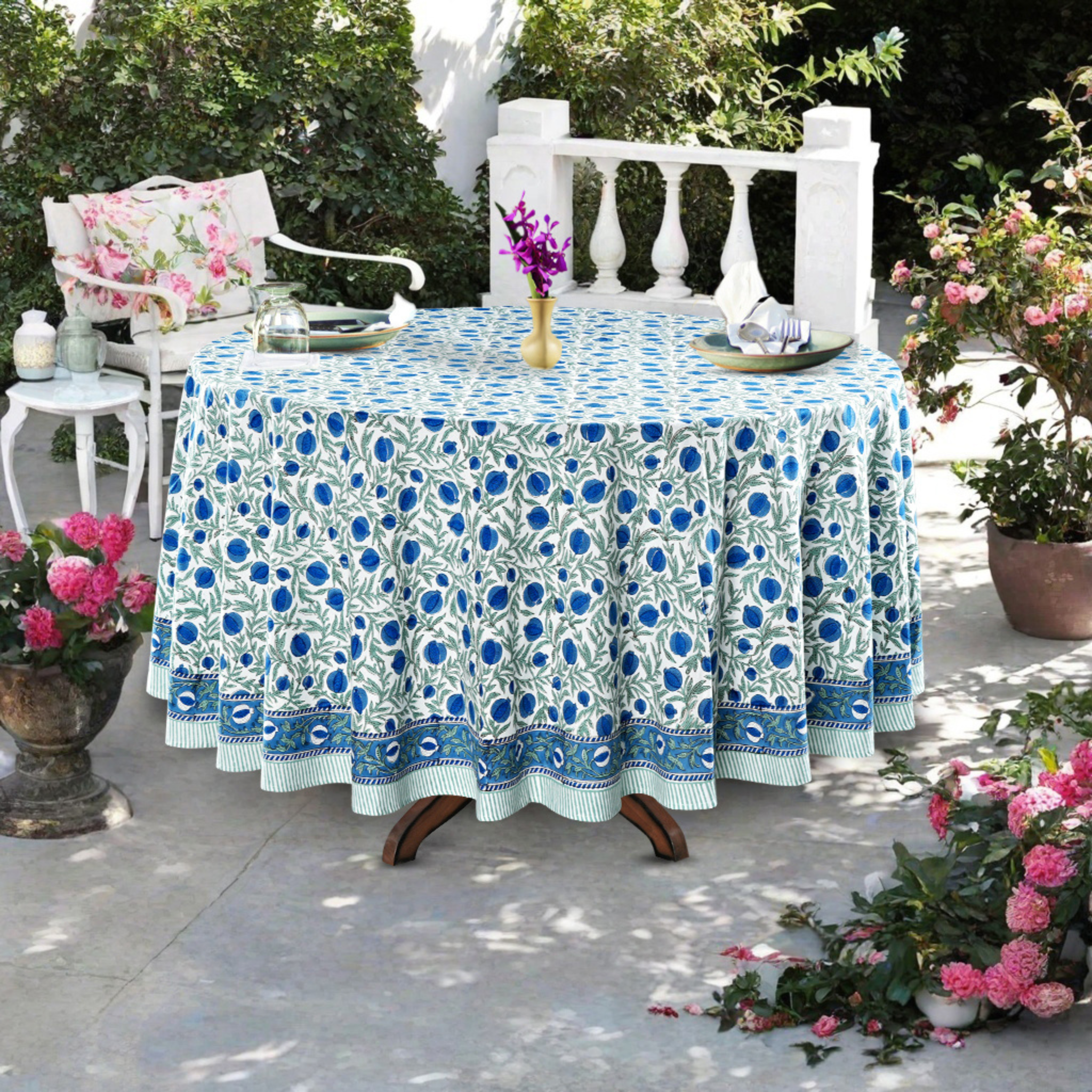 Tablecloth with blue floral pattern on a round table outdoors.