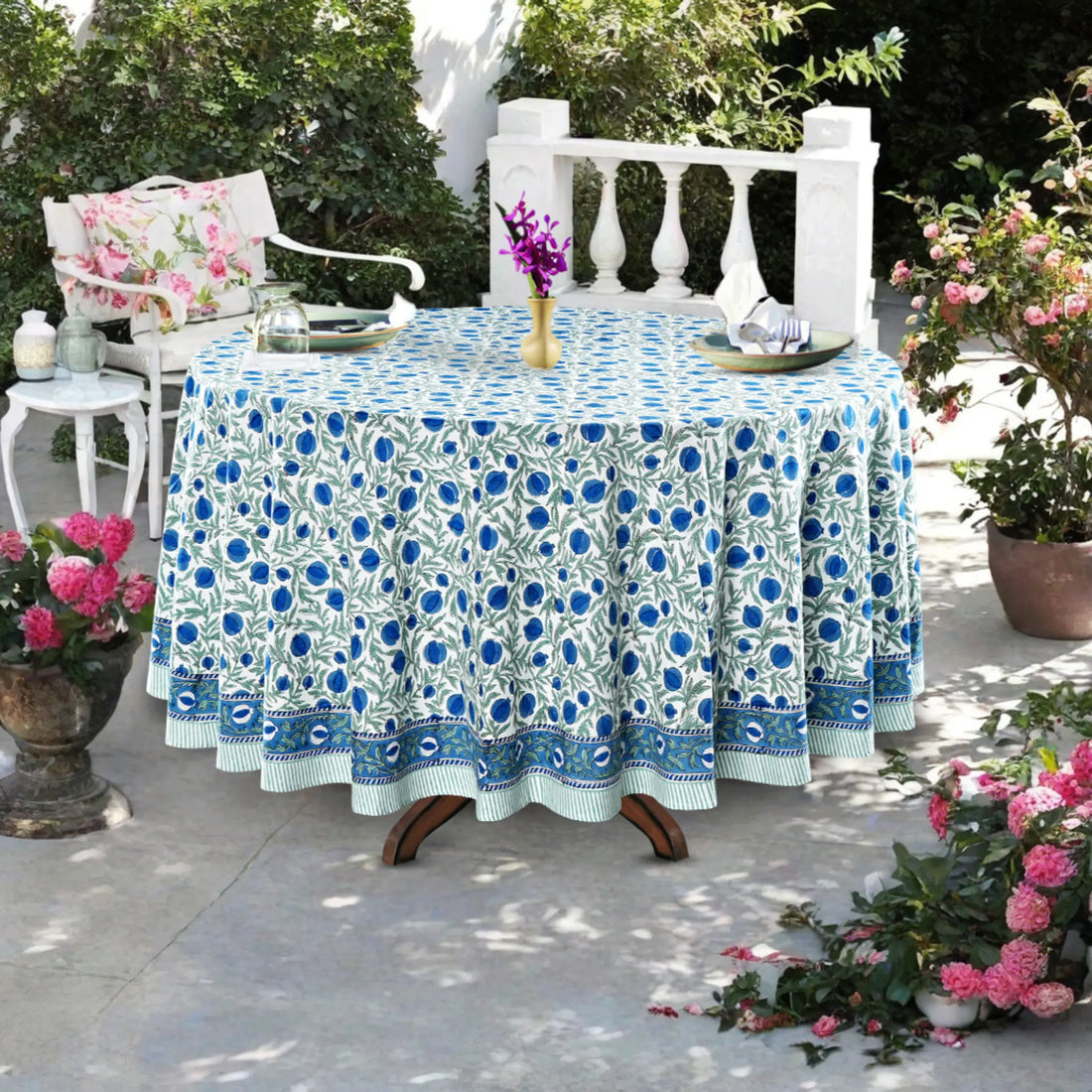 Tablecloth with blue floral pattern on a round table outdoors.