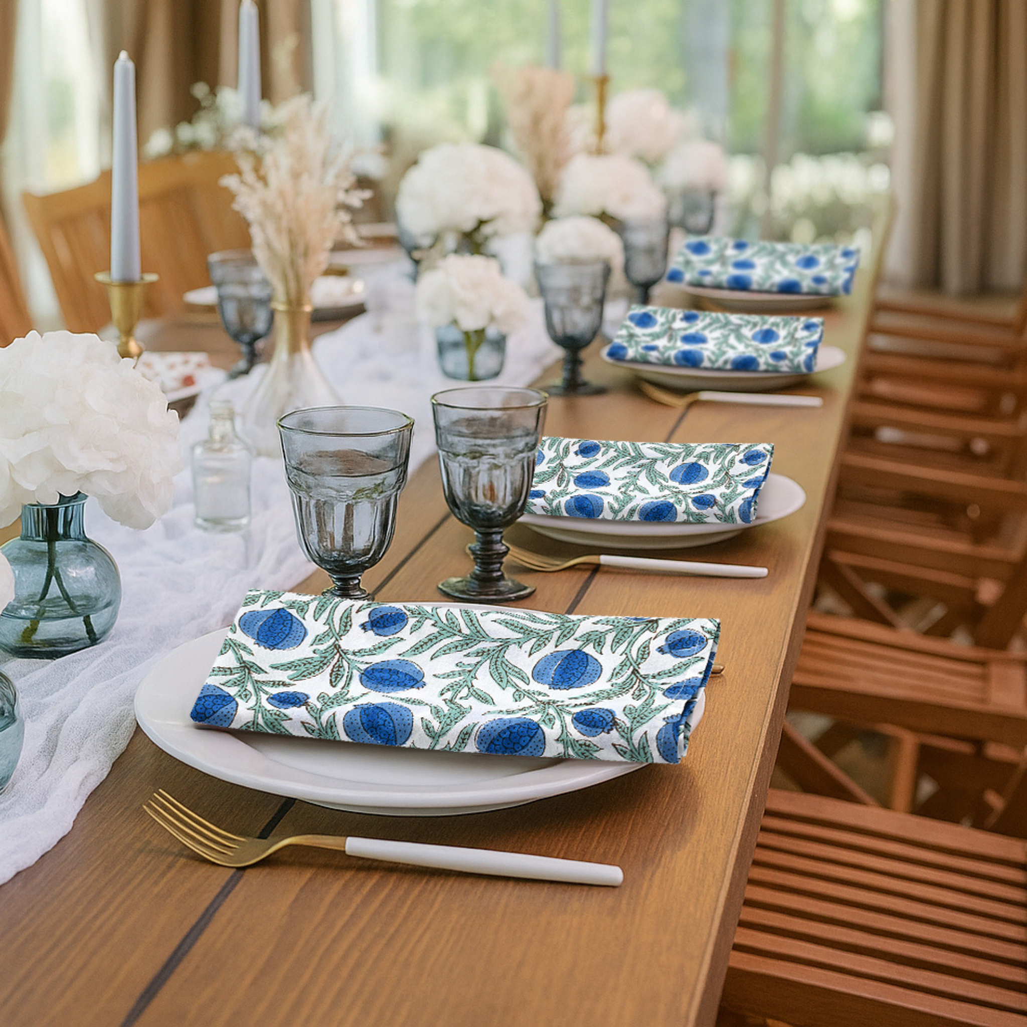Dining table set with floral-patterned plates and napkins in a bright room.