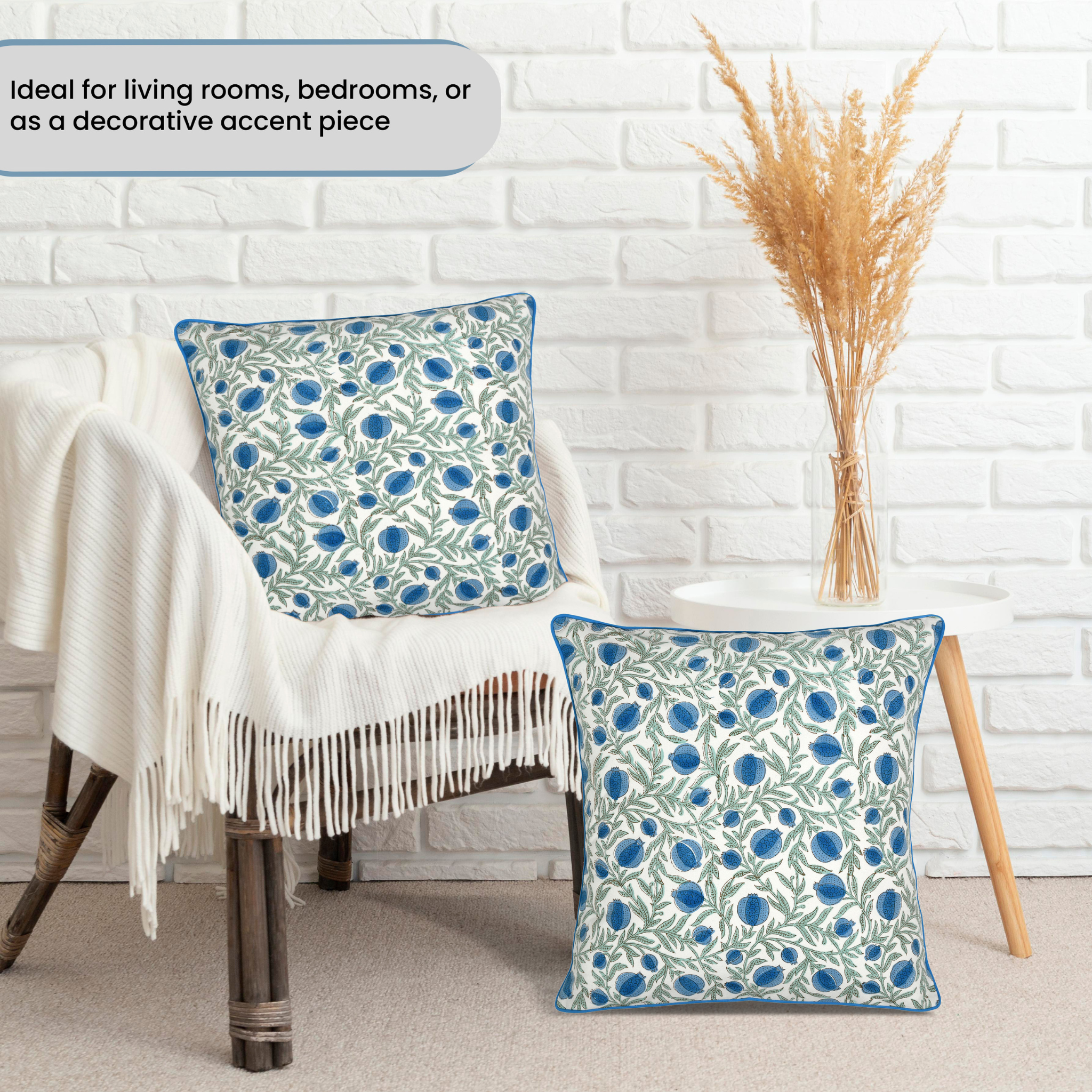 Floral patterned cushions on a chair against a white brick wall.