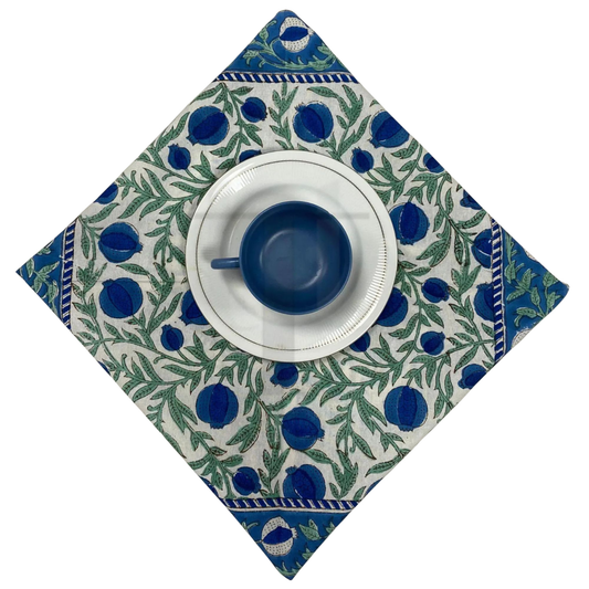 Ceramic cup and saucer on a decorative blue and green patterned napkin
