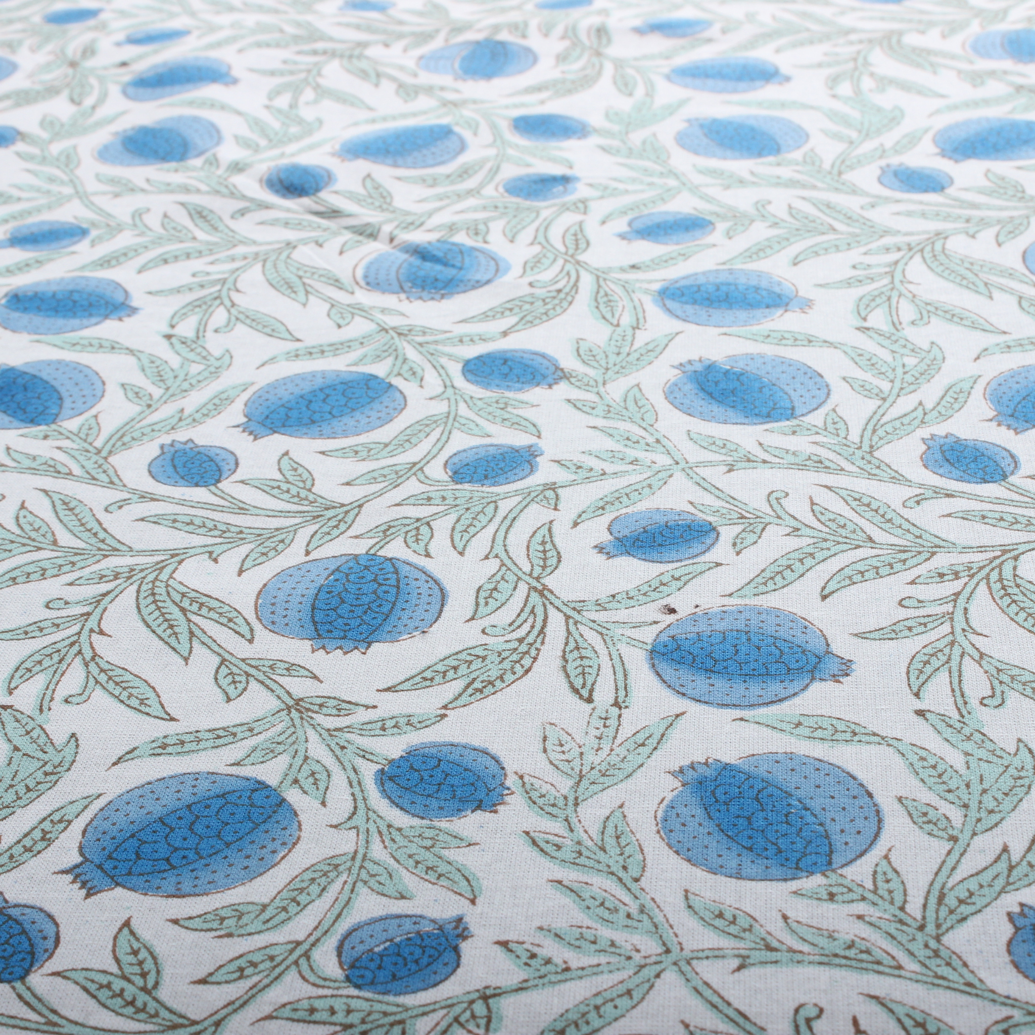 Patterned fabric with blue and green design on a white background