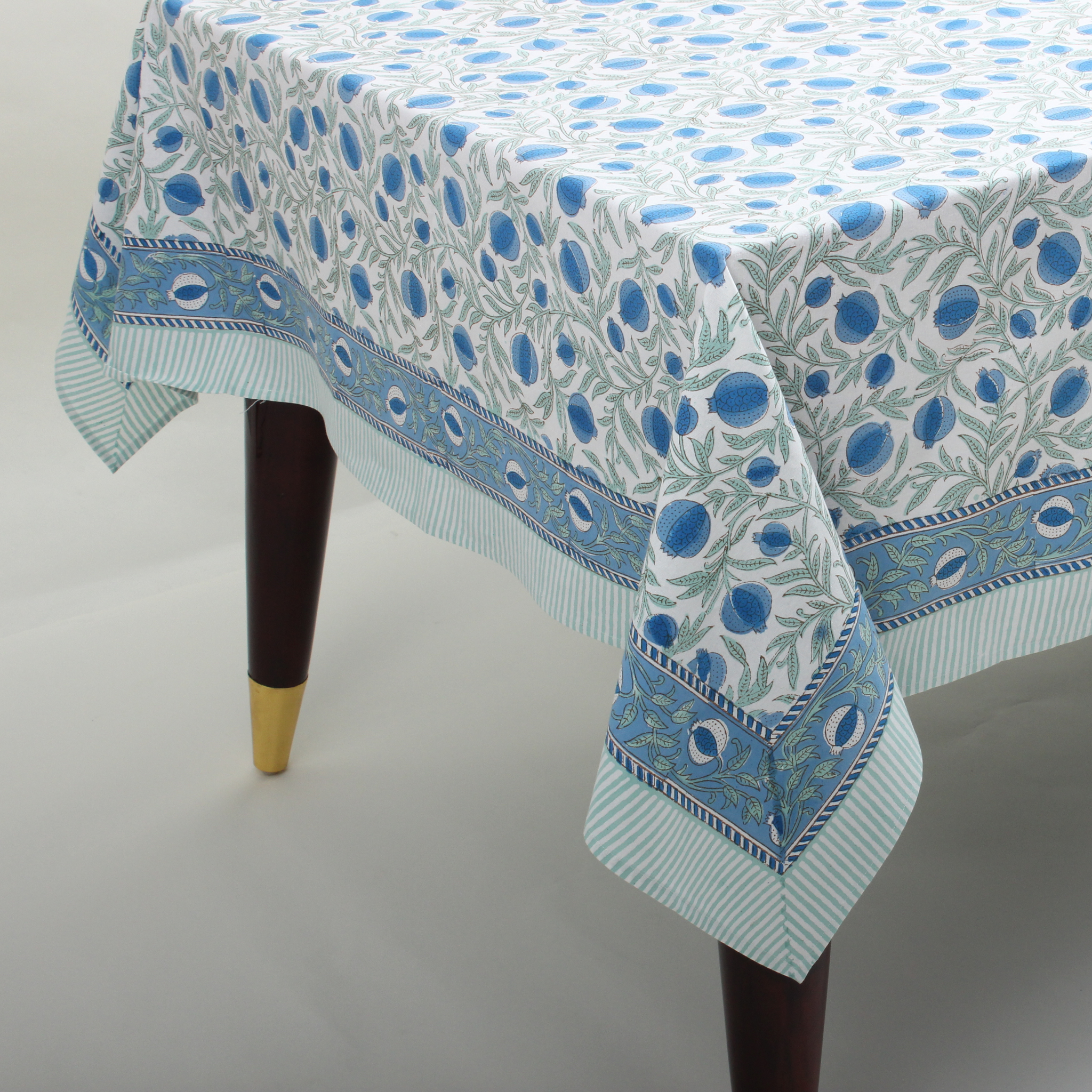 Tablecloth with blue and green pattern on a plain background