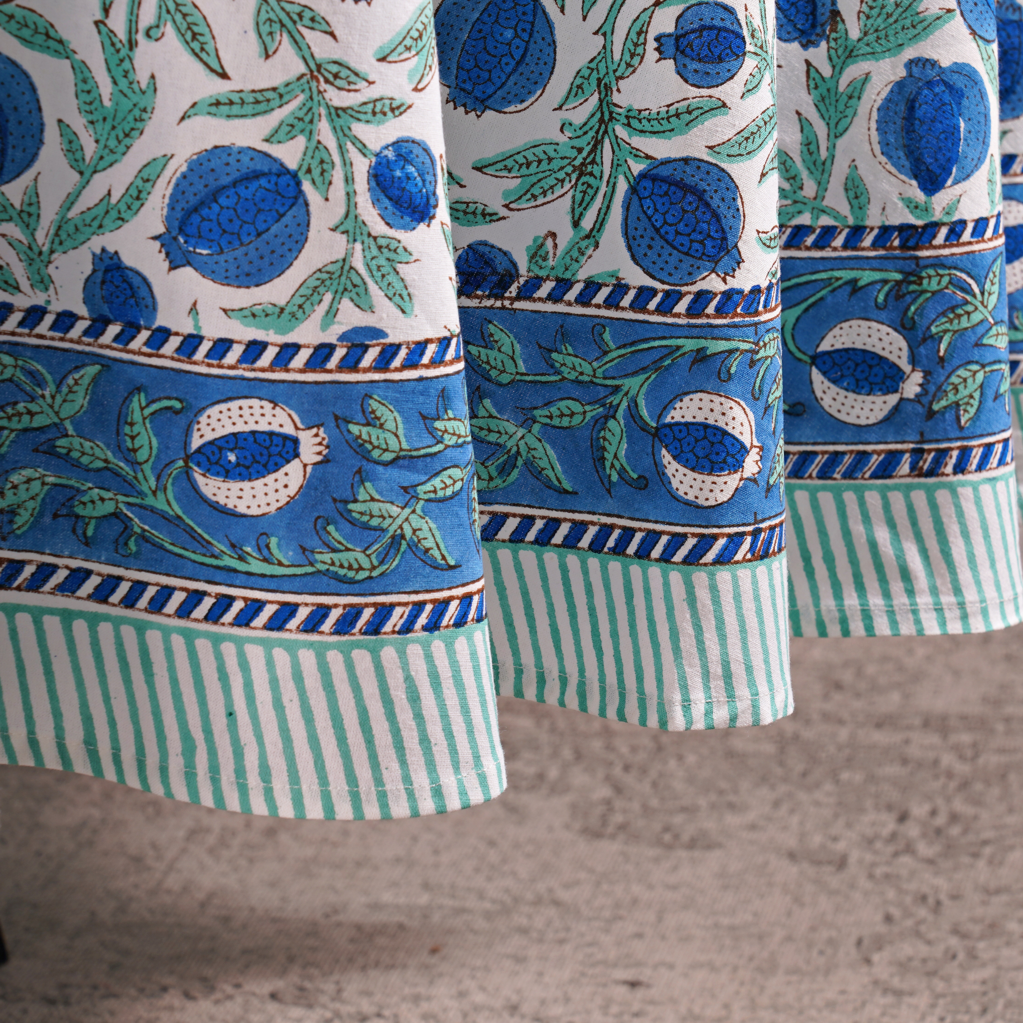 Close-up of patterned fabric with blue and green design on a neutral background