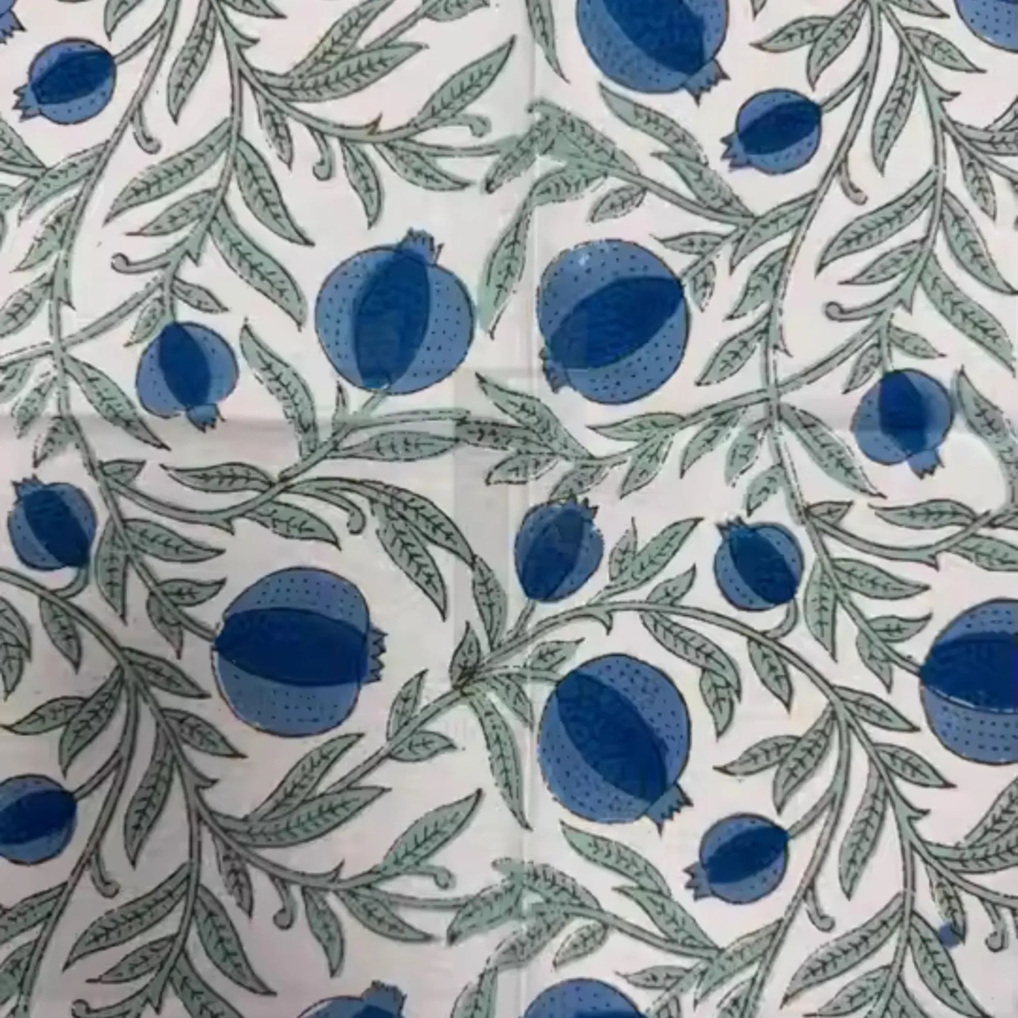 Pattern of blue pomegranates and green leaves on a white background