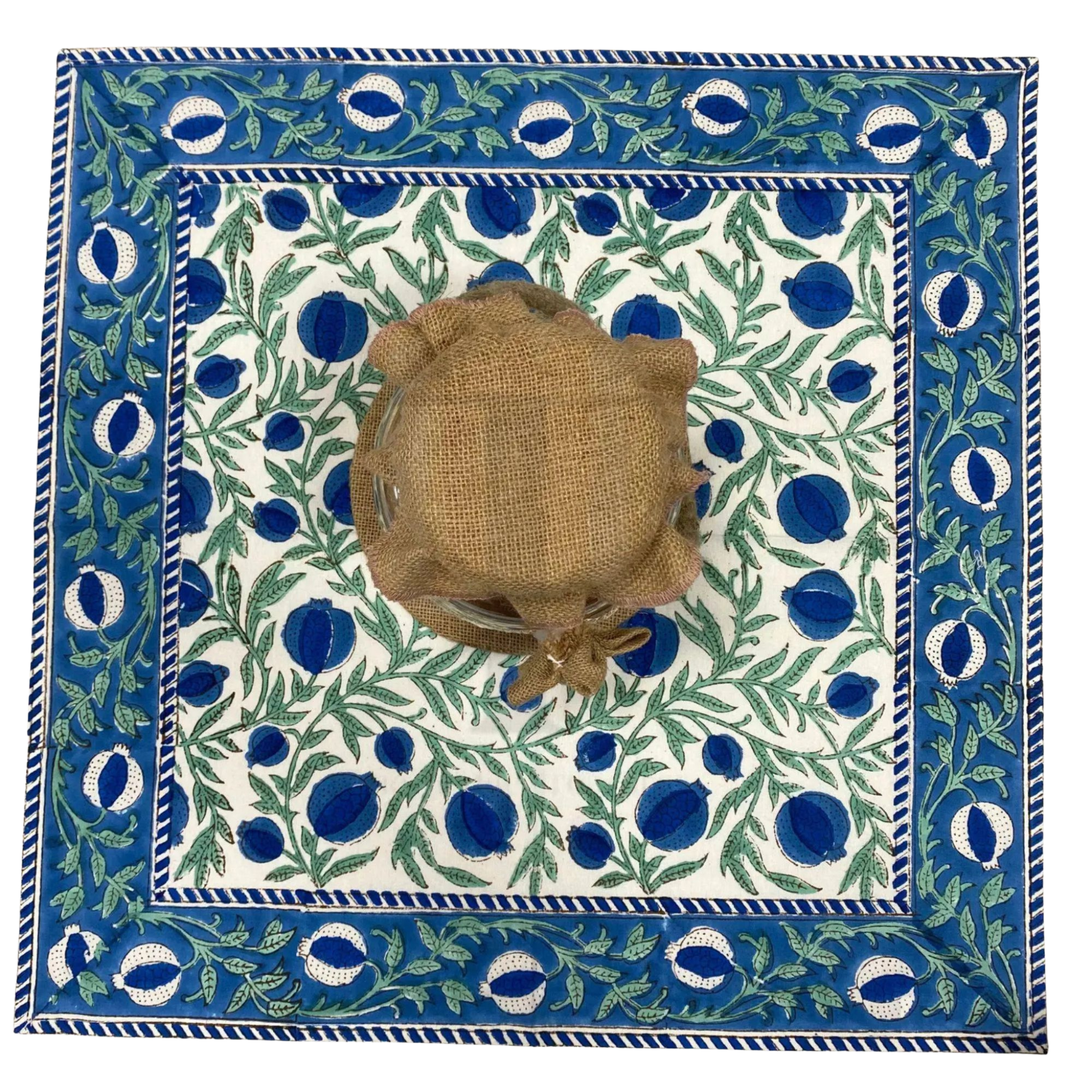 Decorative tablecloth with a blue and green pattern and a woven basket in the center.