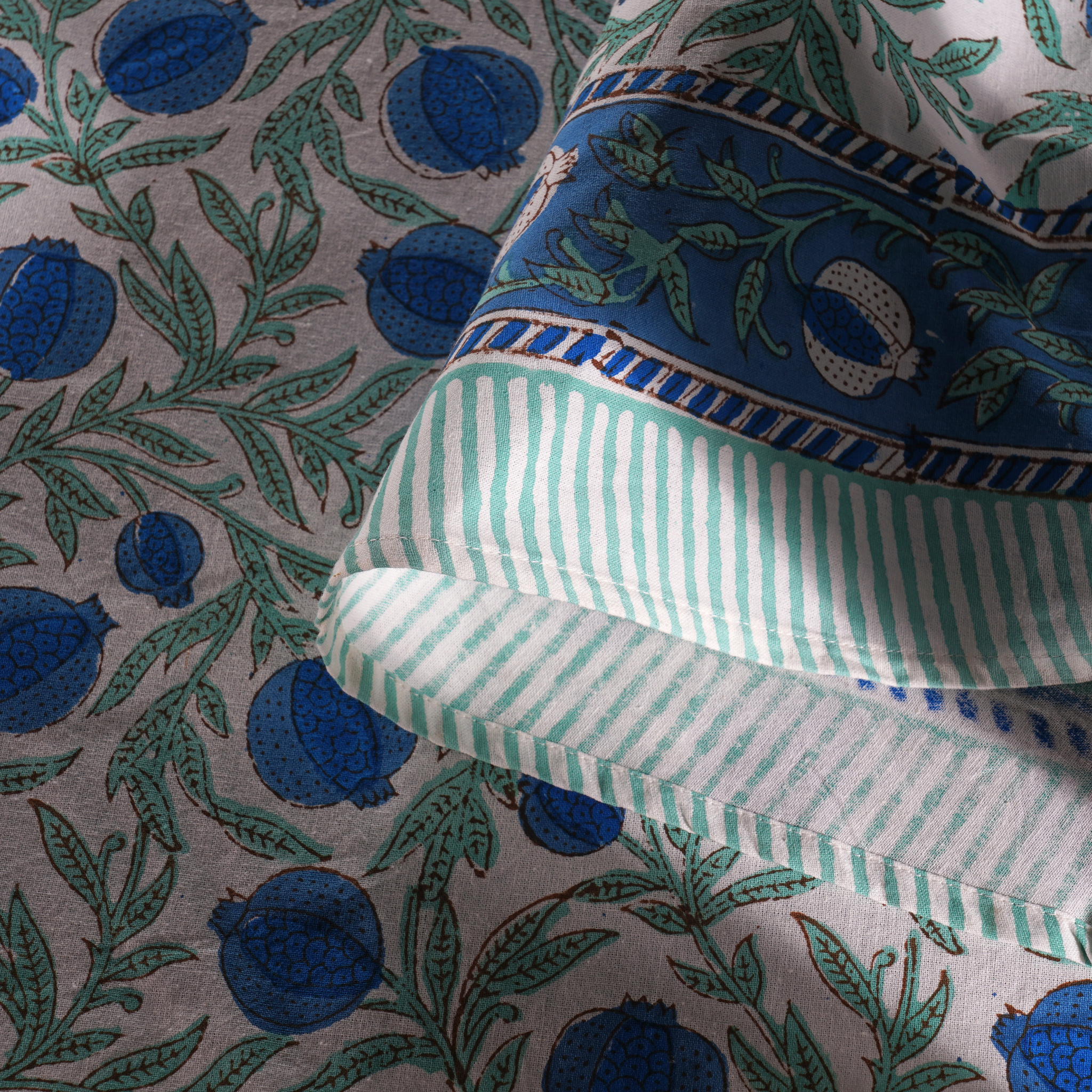 Close-up of fabric with blue floral and green striped patterns