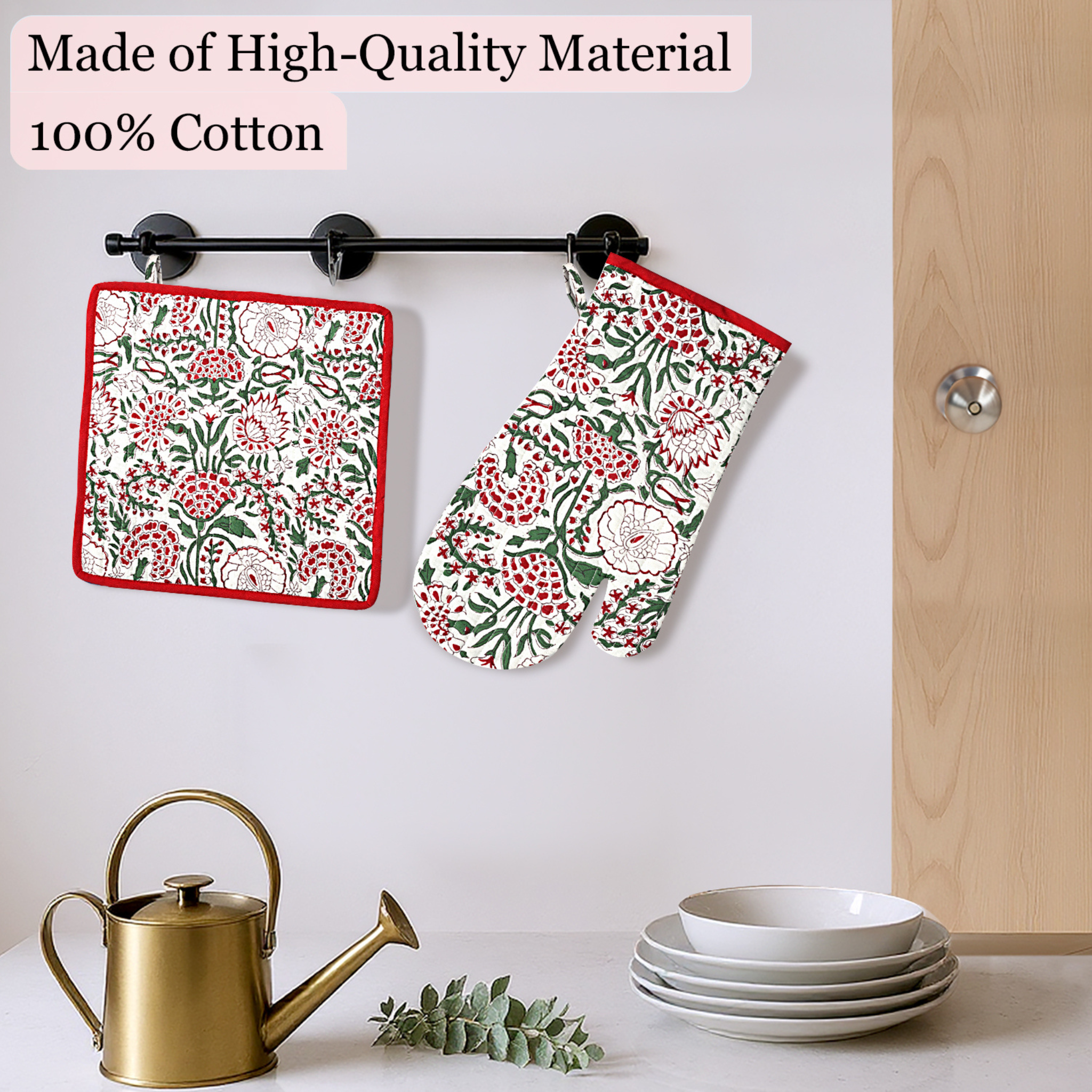 Floral-patterned pot holder and oven mitt hanging on a rack with kitchen items below.