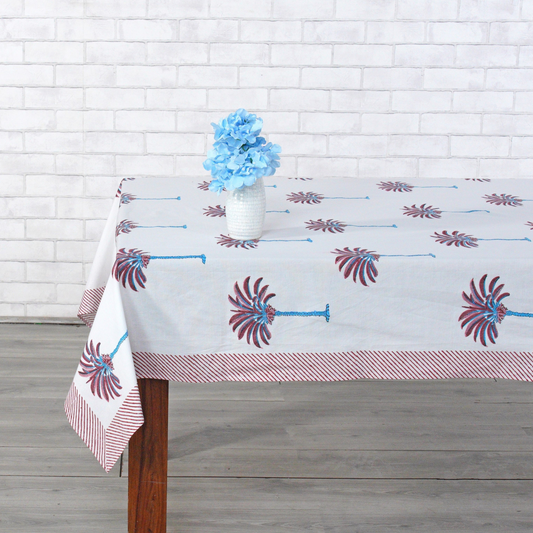 Decorative tablecloth with red and white palm tree pattern on a plain background with striped border