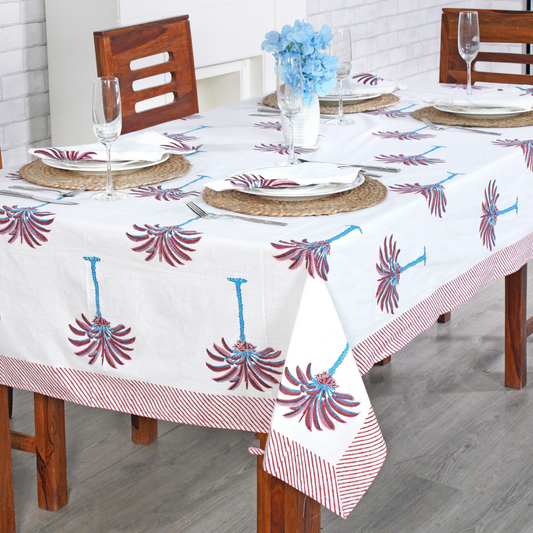 Decorative tablecloth with red and white palm tree pattern on a plain background with striped border