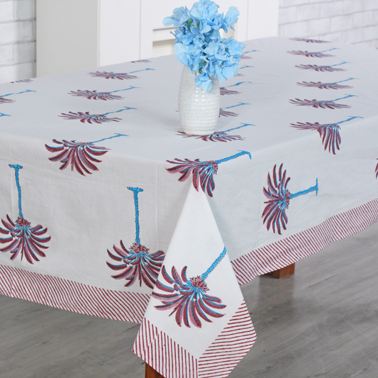 Decorative tablecloth with red and white palm tree pattern on a plain background with striped border