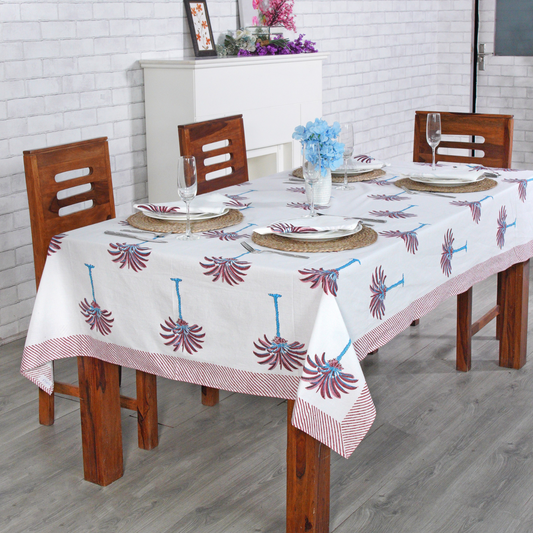 Decorative tablecloth with red and white palm tree pattern on a plain background with striped border
