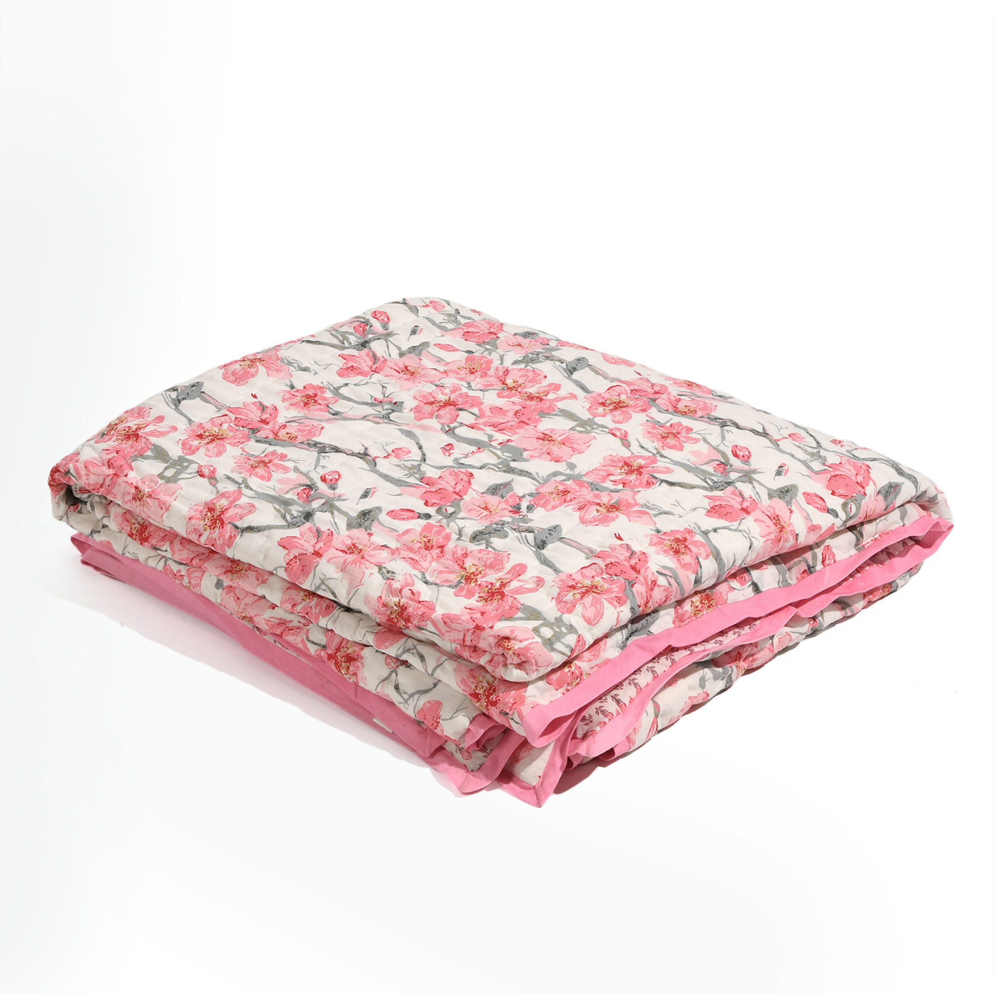Folded floral blanket with pink and gray pattern on a white background