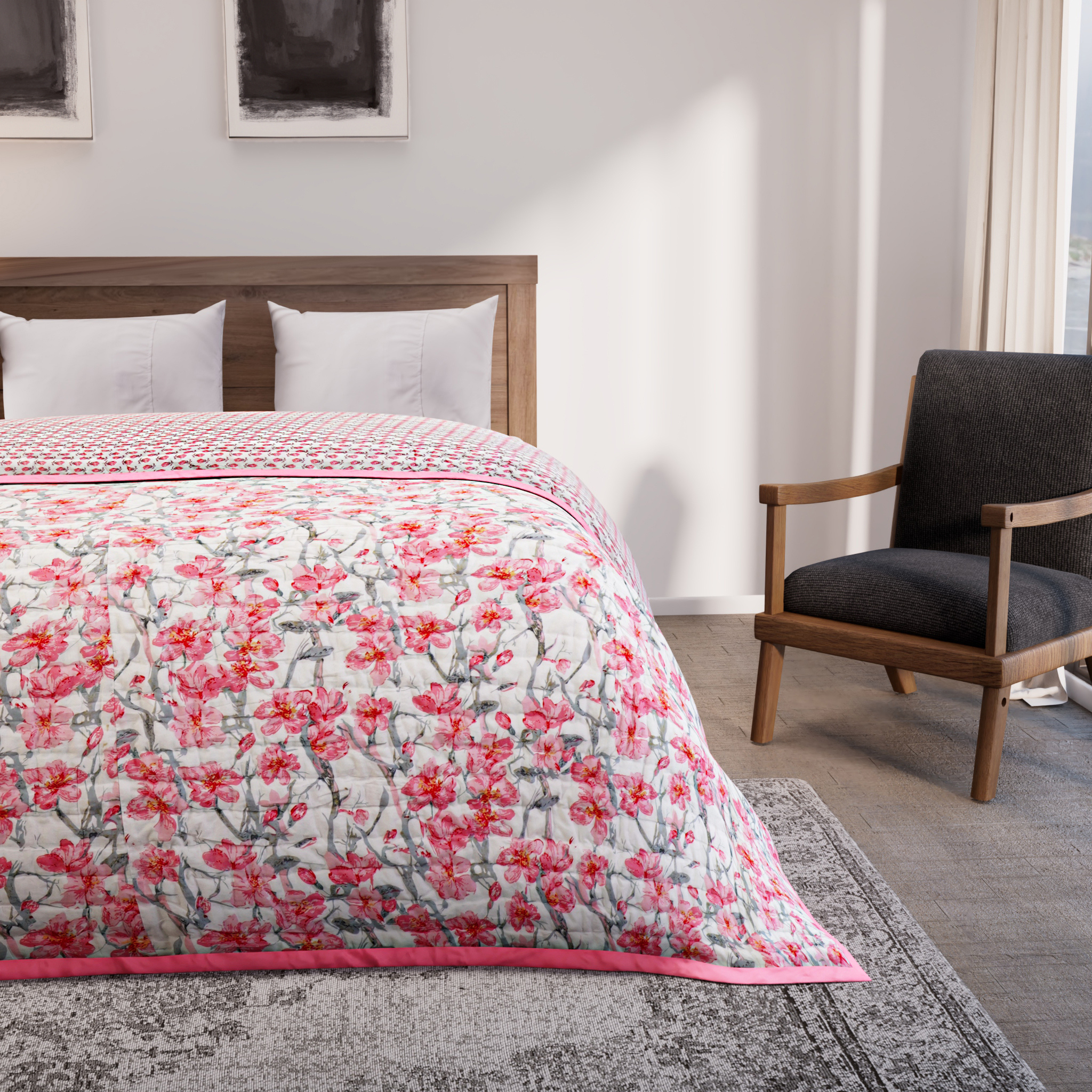 Bed with pink floral quilt in a bedroom setting with a chair and rug.