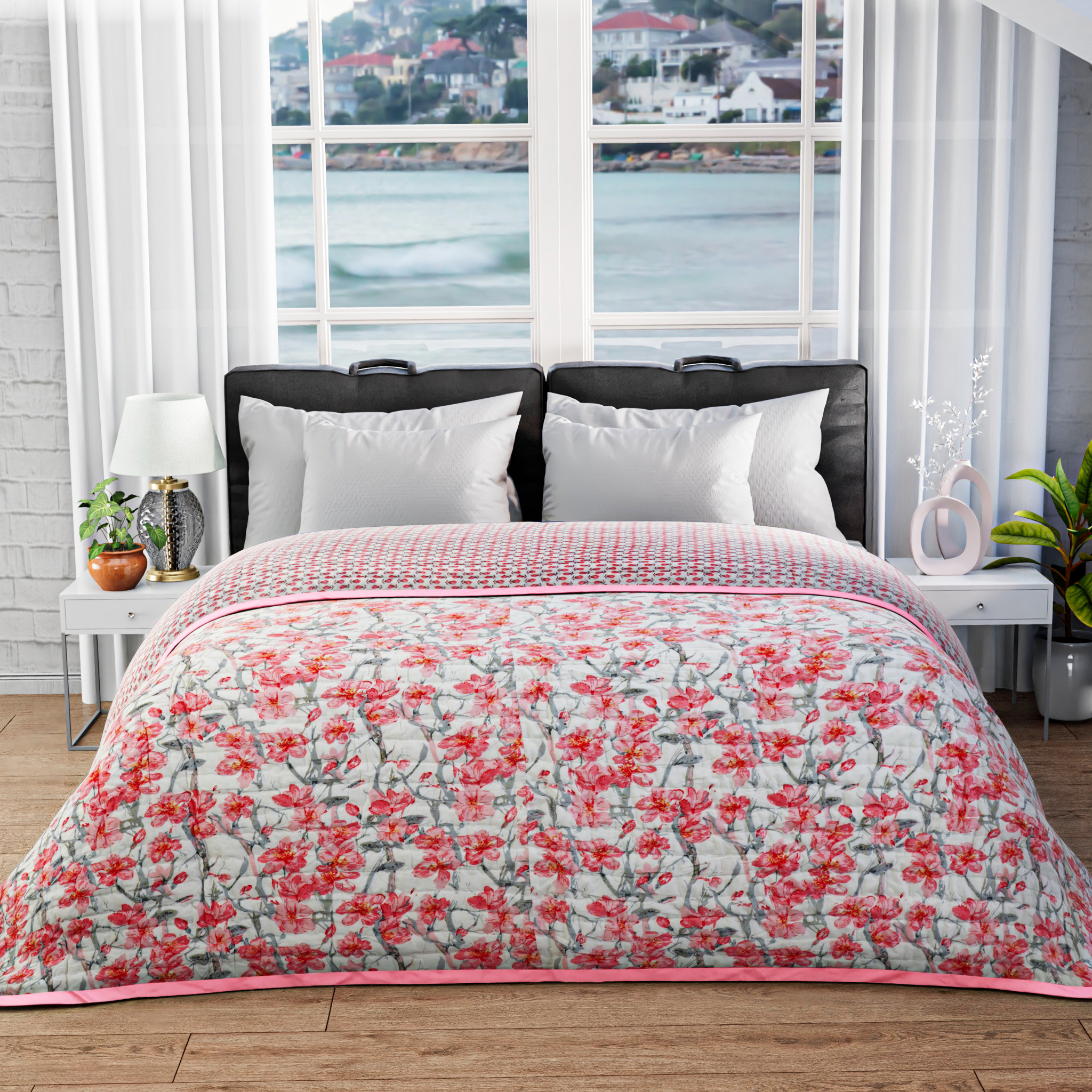 Floral quilt on a bed with a window view of water and buildings