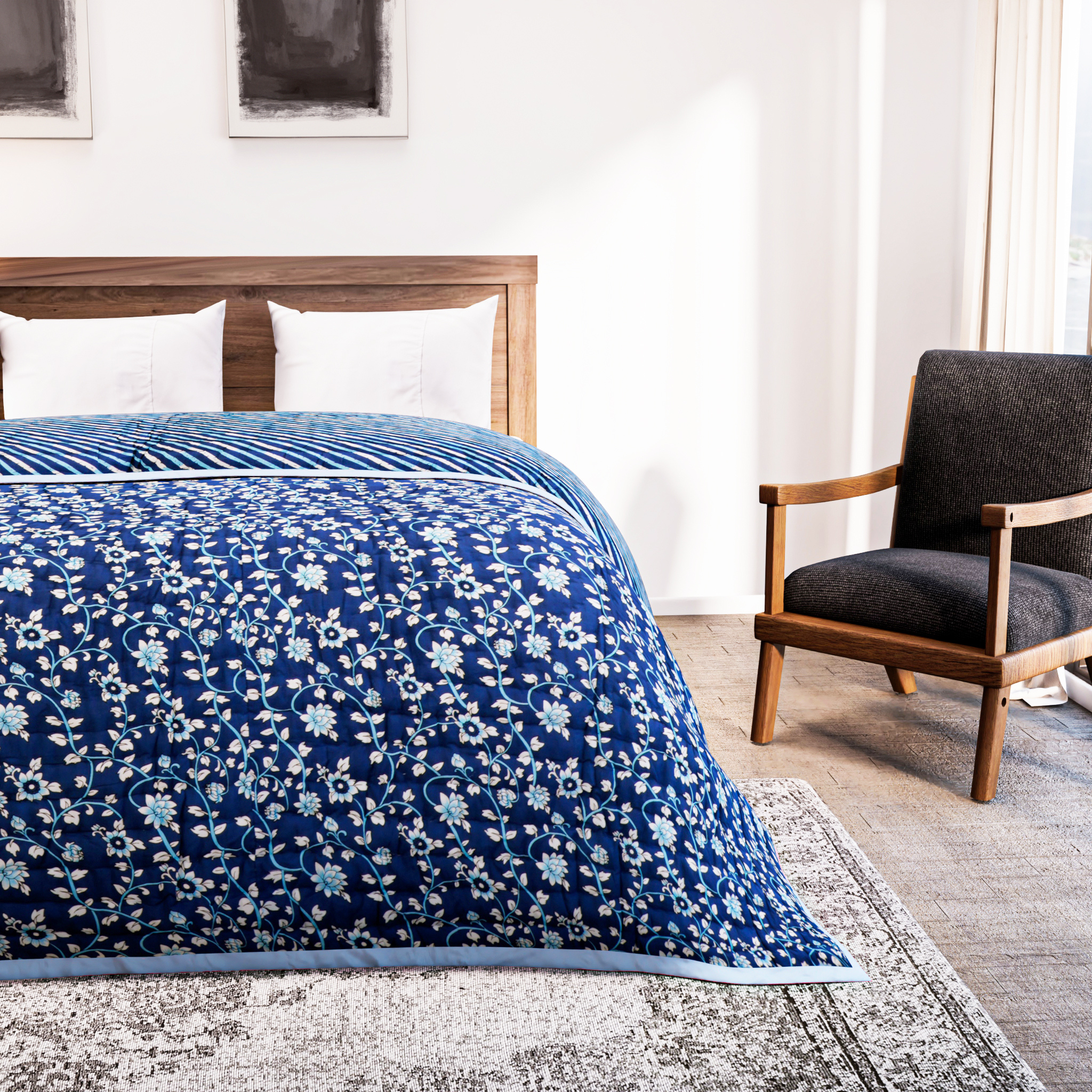 Bed with blue floral quilt in a bedroom setting with a chair and rug.