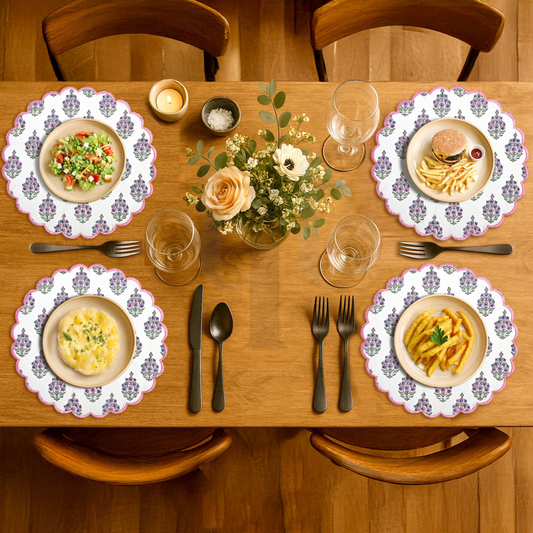 Dining table set with plates of food, glasses, and cutlery on a wooden table.