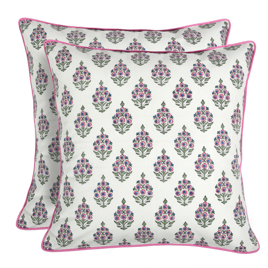 Two floral patterned pillows with pink accents on a white background