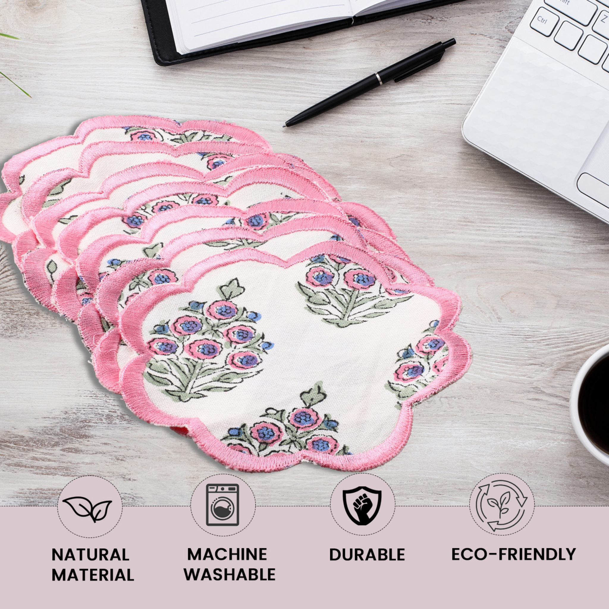 Set of floral pads on a desk with laptop, pen, and coffee cup.