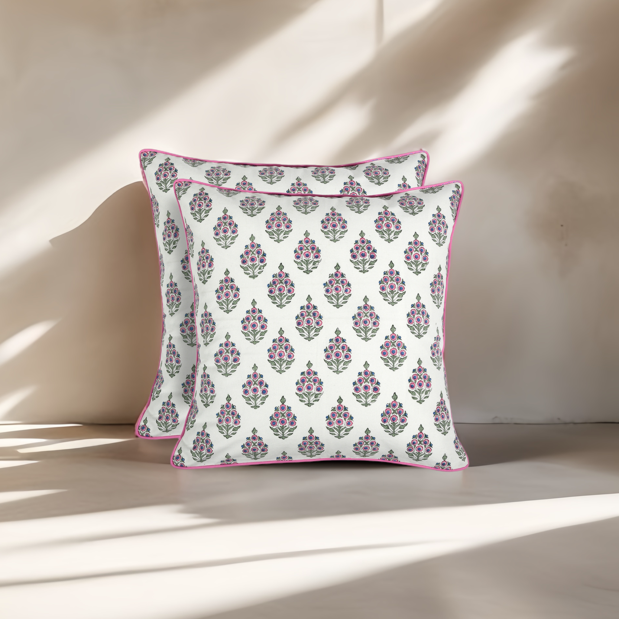 Two floral patterned pillows on a neutral background