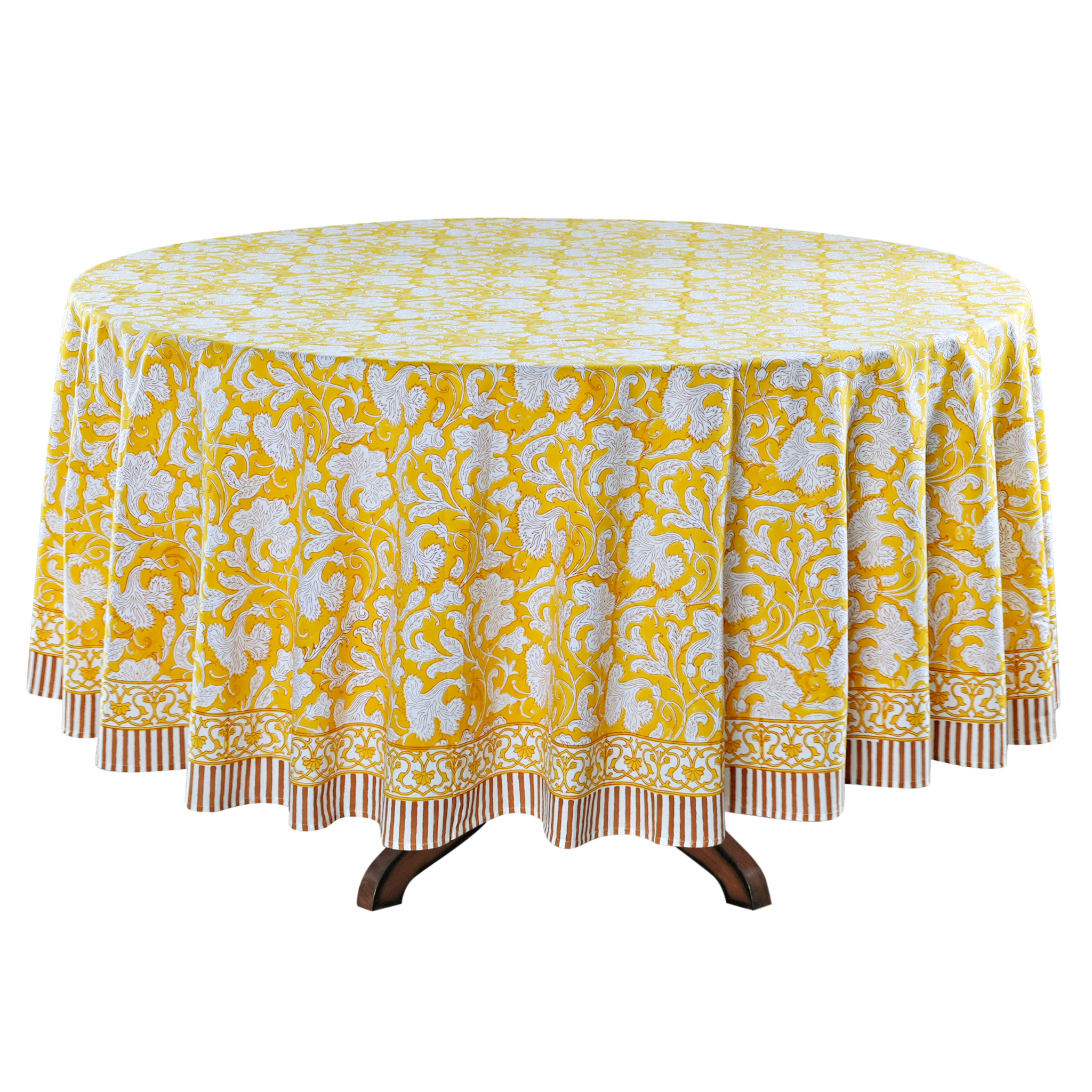Round table with a yellow and white patterned tablecloth on a white background