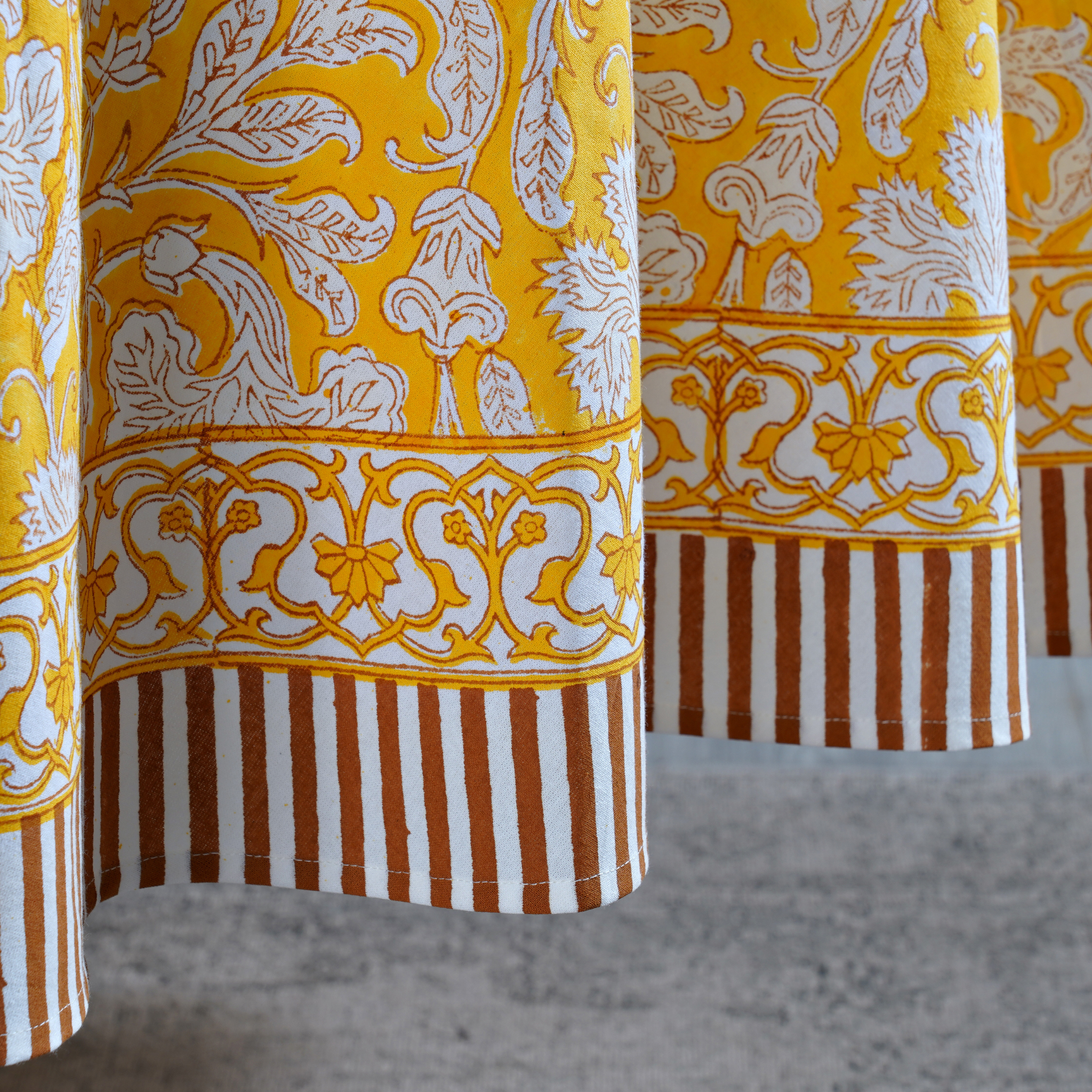 Close-up of patterned fabric with yellow, white, and brown colors.