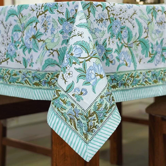Floral tablecloth with a matching napkin on a wooden table.