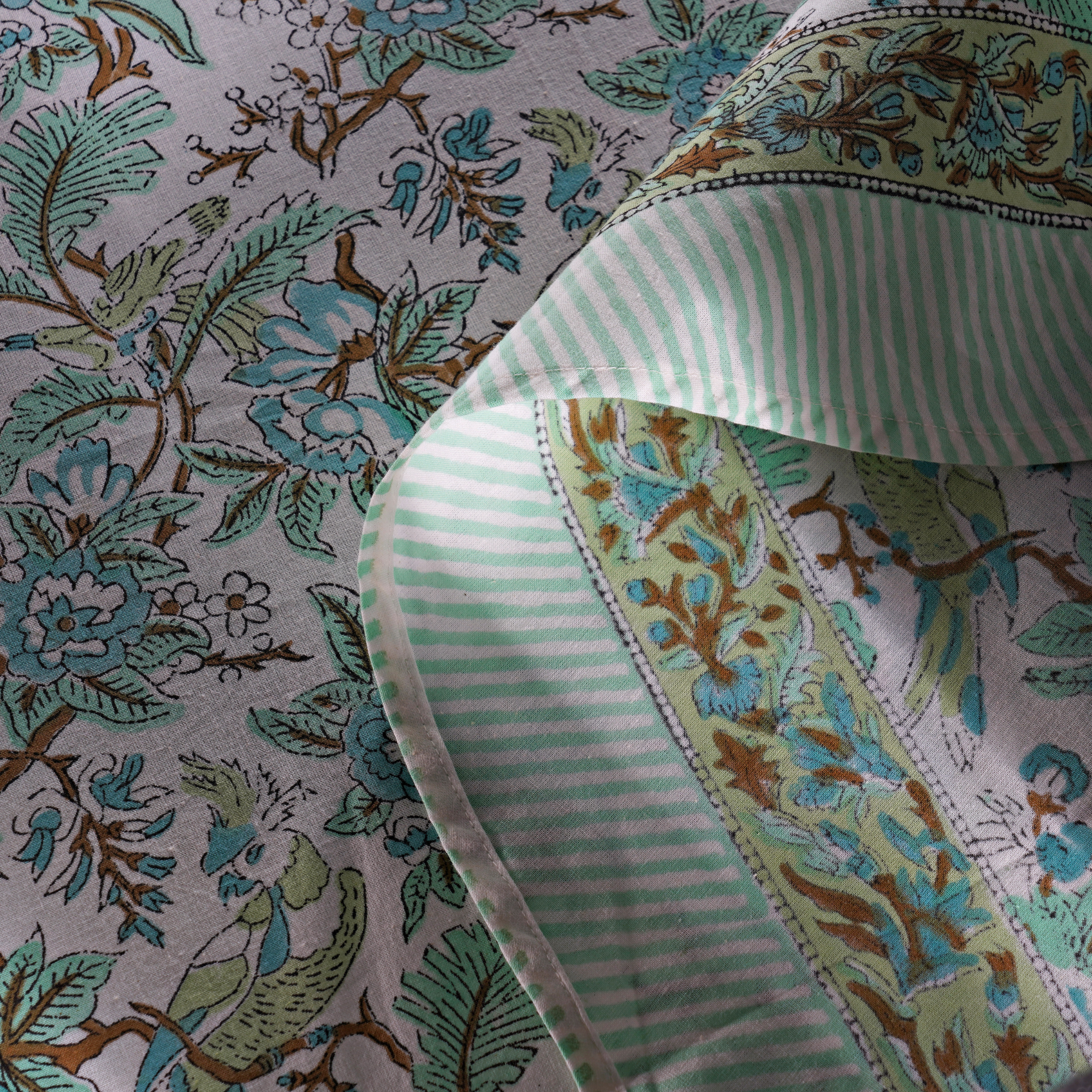 Close-up of floral fabric with a green and white striped ribbon
