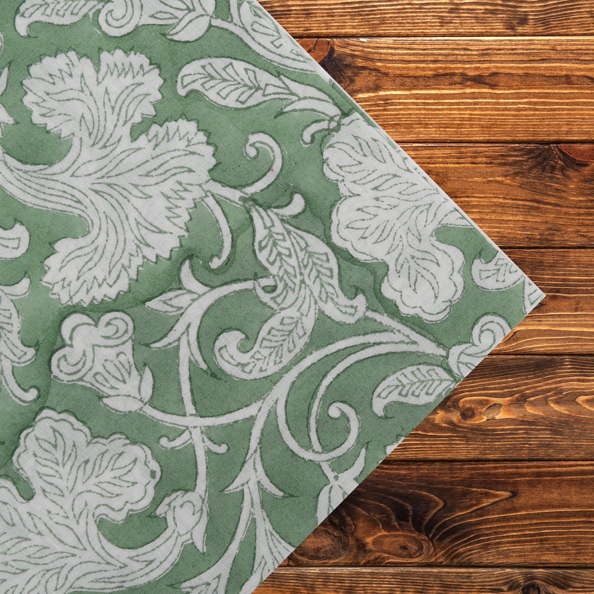 Green and white floral patterned rug on a wooden floor