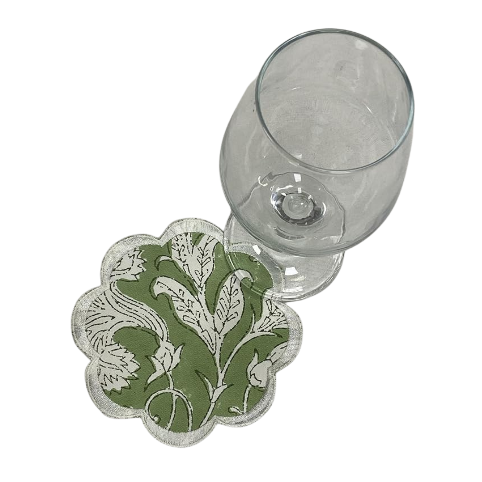 Decorative coaster with floral pattern next to a glass on a white background