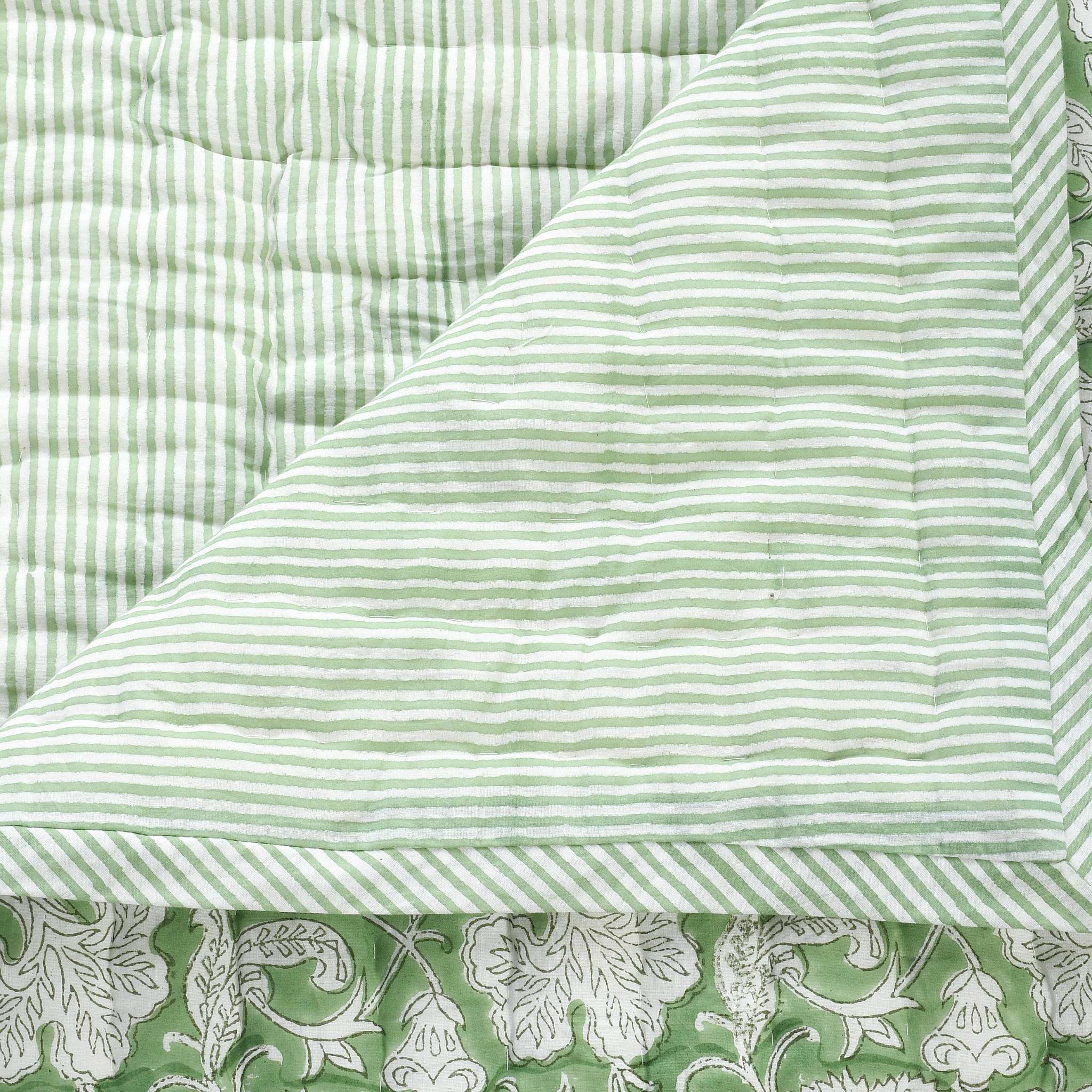 Close-up of green and white striped fabric with floral border