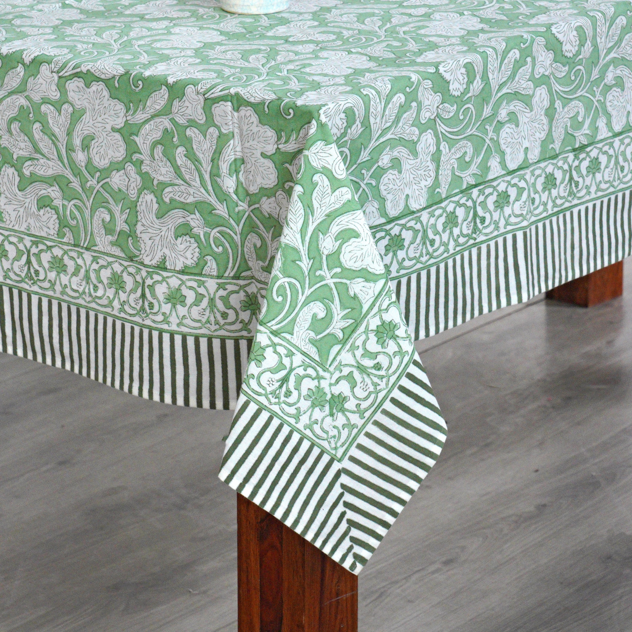 Green and white patterned tablecloth on a wooden table