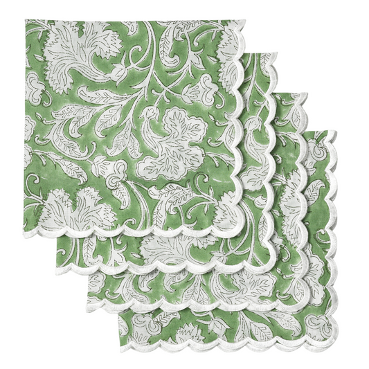 Green and white floral patterned paper napkins with scalloped edge on a white background