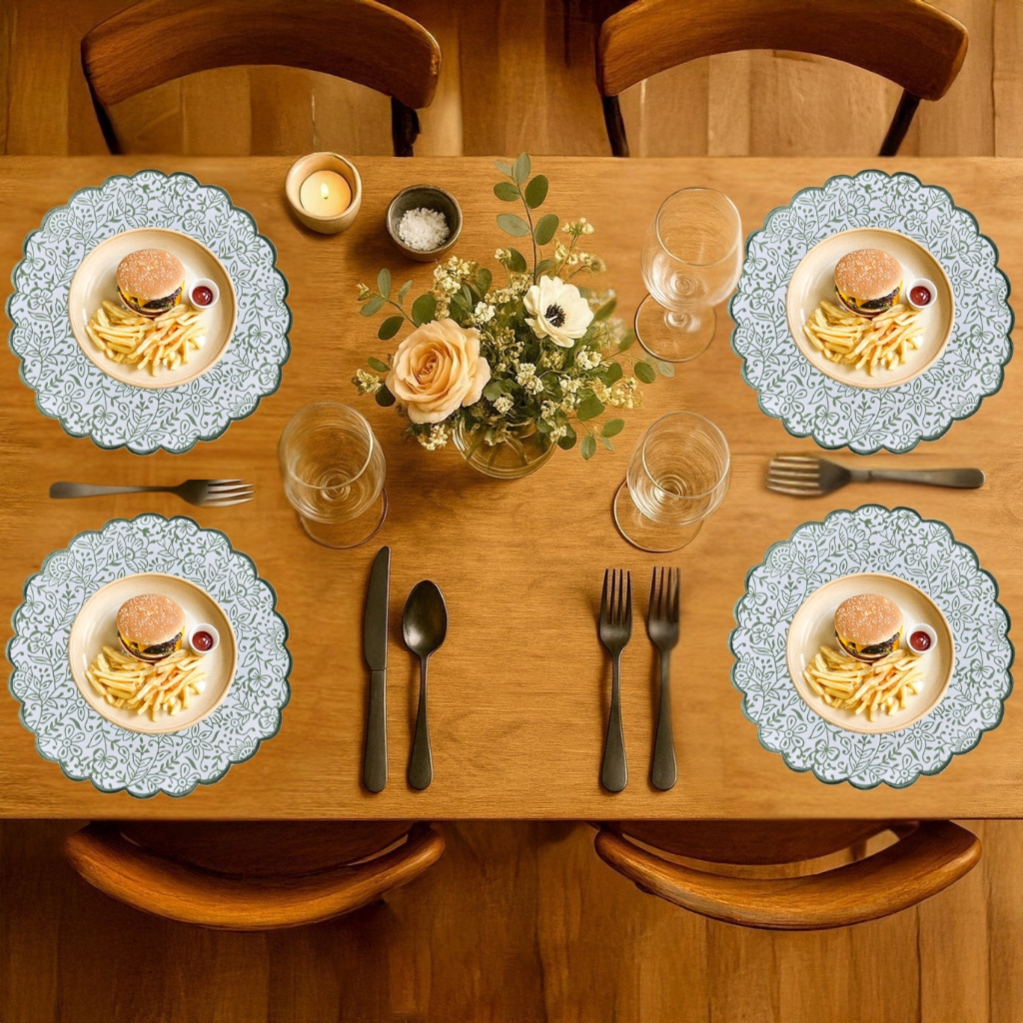 Dining table set with plates of pasta, glasses, cutlery, and a floral centerpiece.