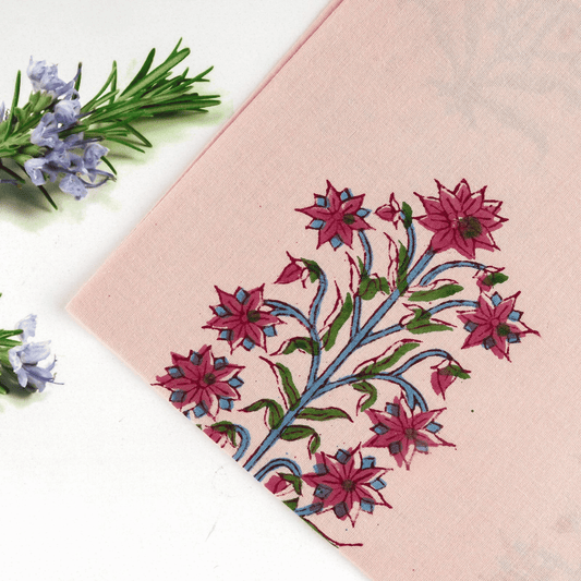 Embroidered pink fabric with floral design on a white background