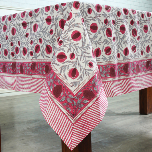 Decorative tablecloth with red and white pattern on a wooden table.