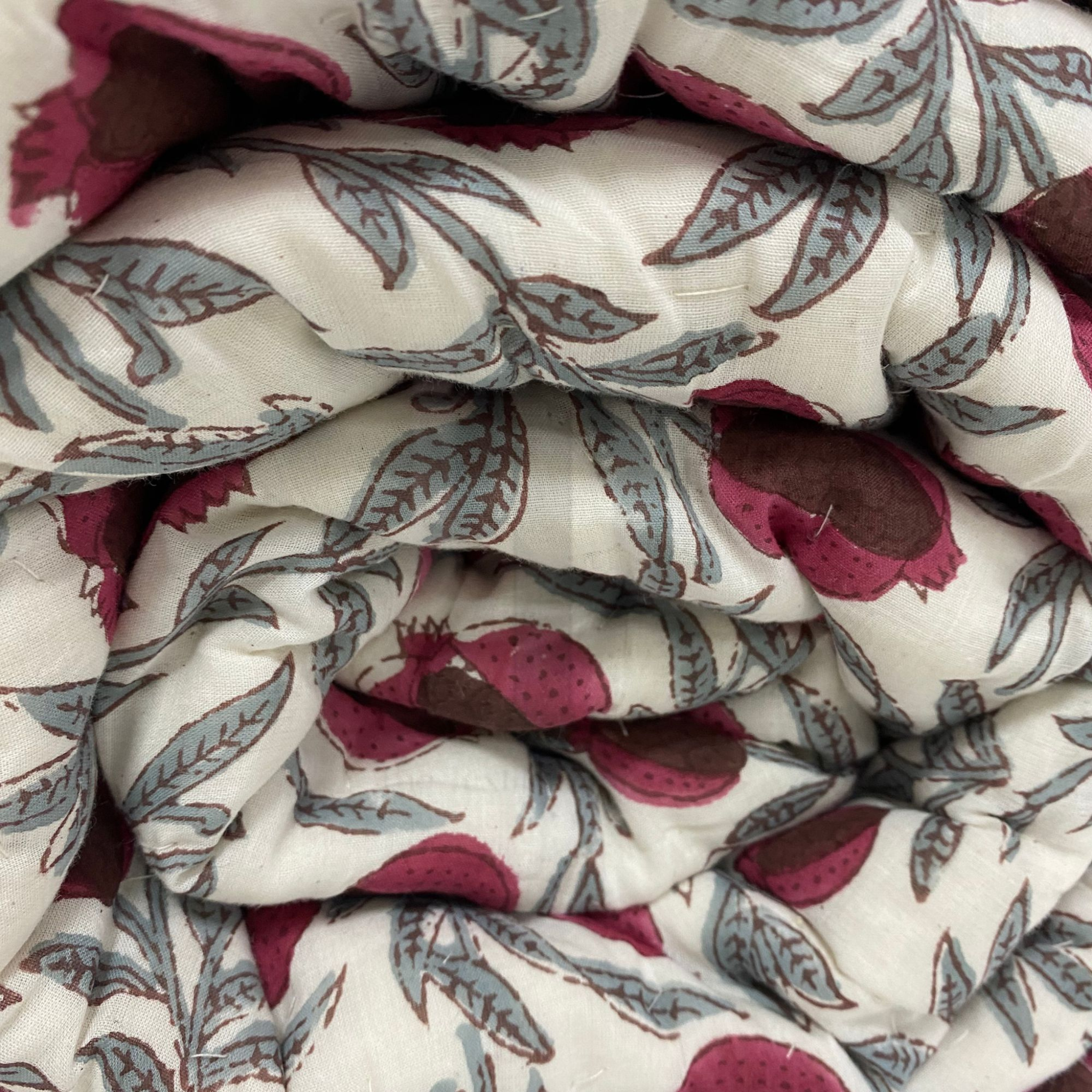 Close-up of patterned fabric with pink and gray design on a white background
