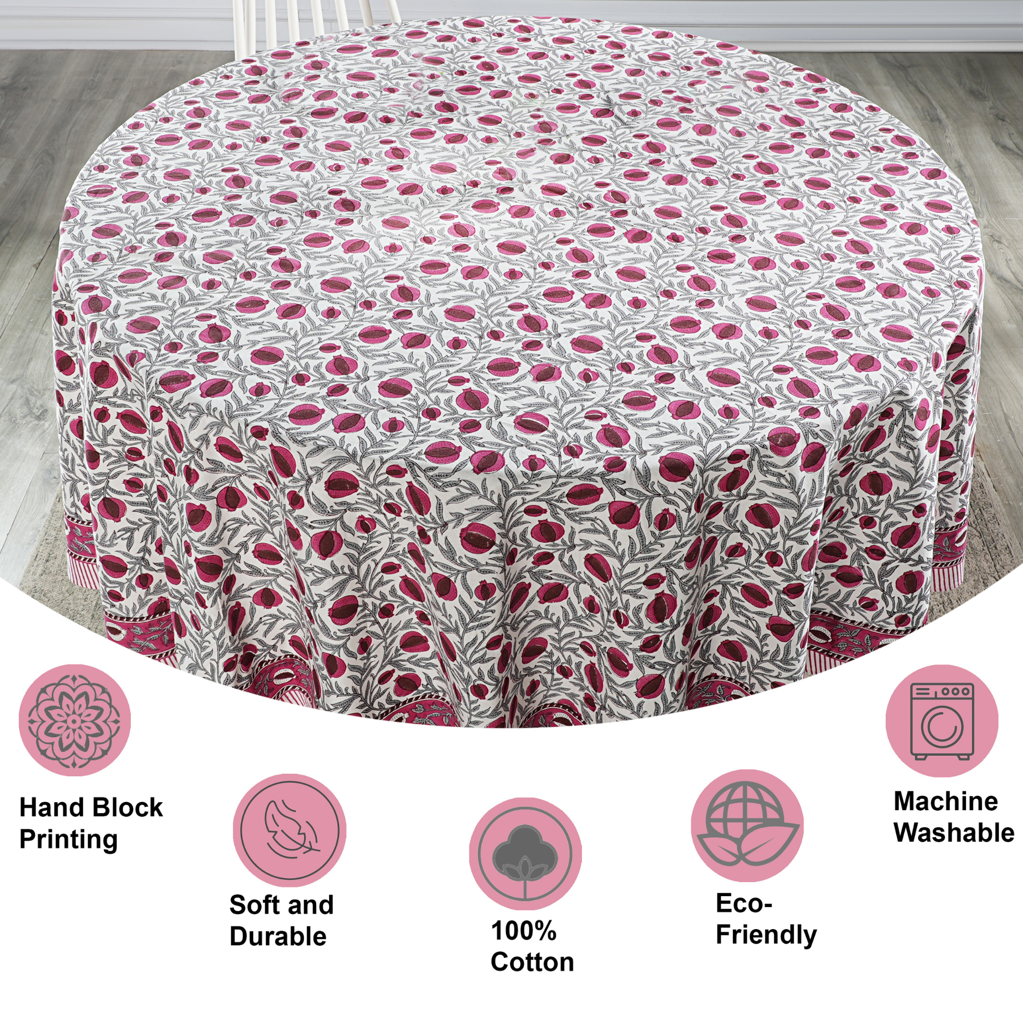 Round tablecloth with pink floral pattern on a wooden floor, featuring icons and text about material and care.
