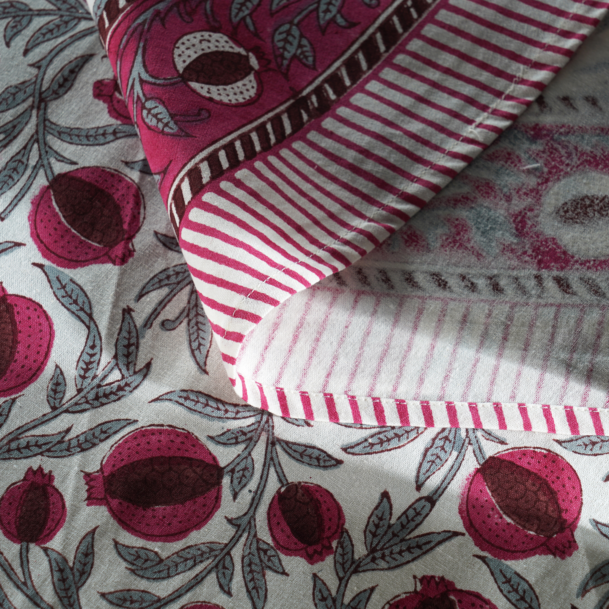 Close-up of fabric with pomegranate pattern and striped design