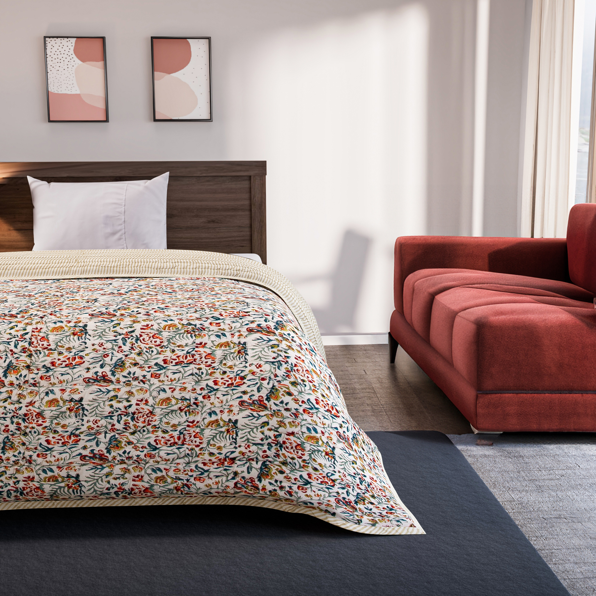 Bedroom with floral comforter, wooden headboard, and red sofa.