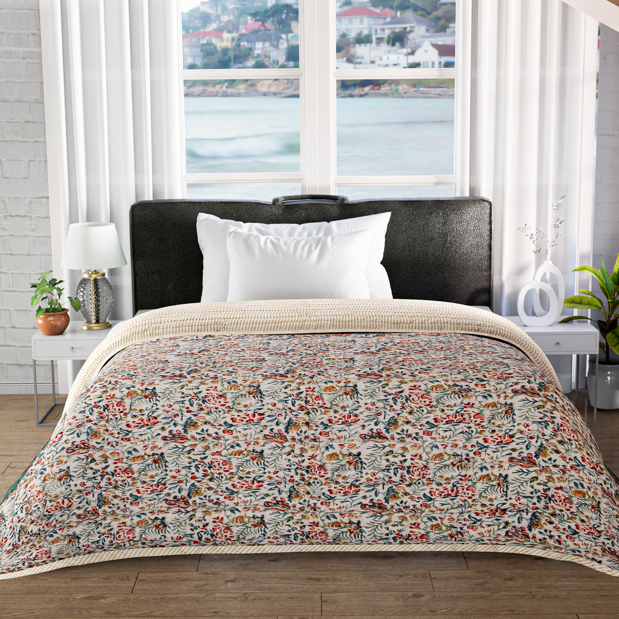 Floral-patterned comforter on a bed in a bedroom with large windows.
