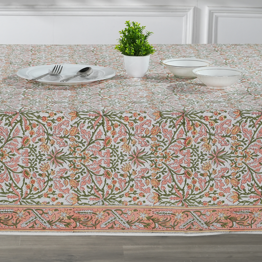 Table setting with a floral patterned tablecloth in a dining room.